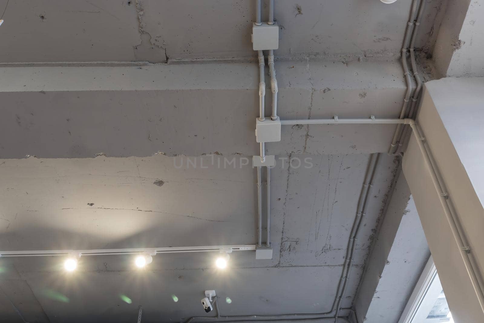 Interior architecture and ceiling design of industrial loft building decorated with modern lamps, glass windows and wall speakers