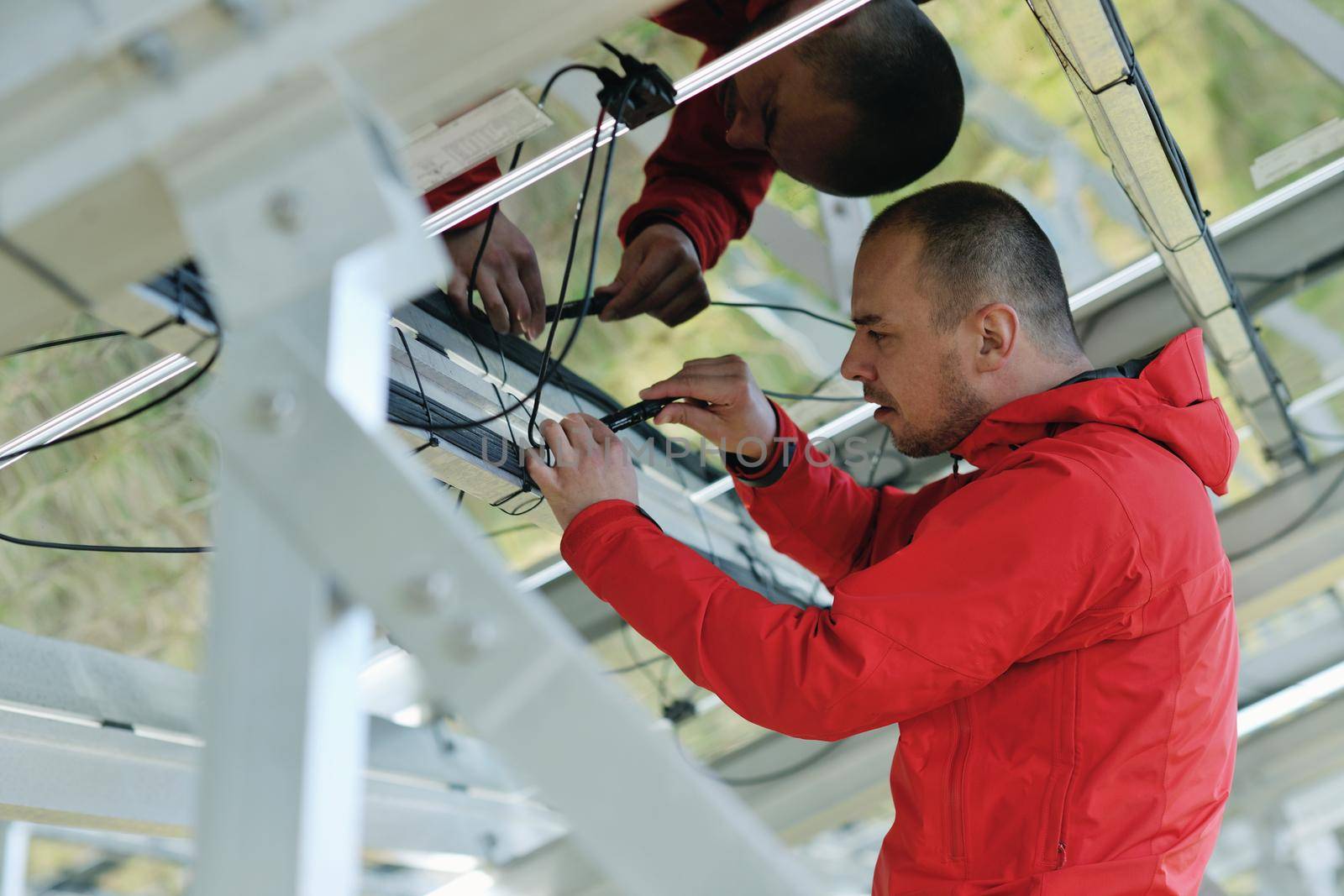 Male engineer at work place, solar panels plant industy in background