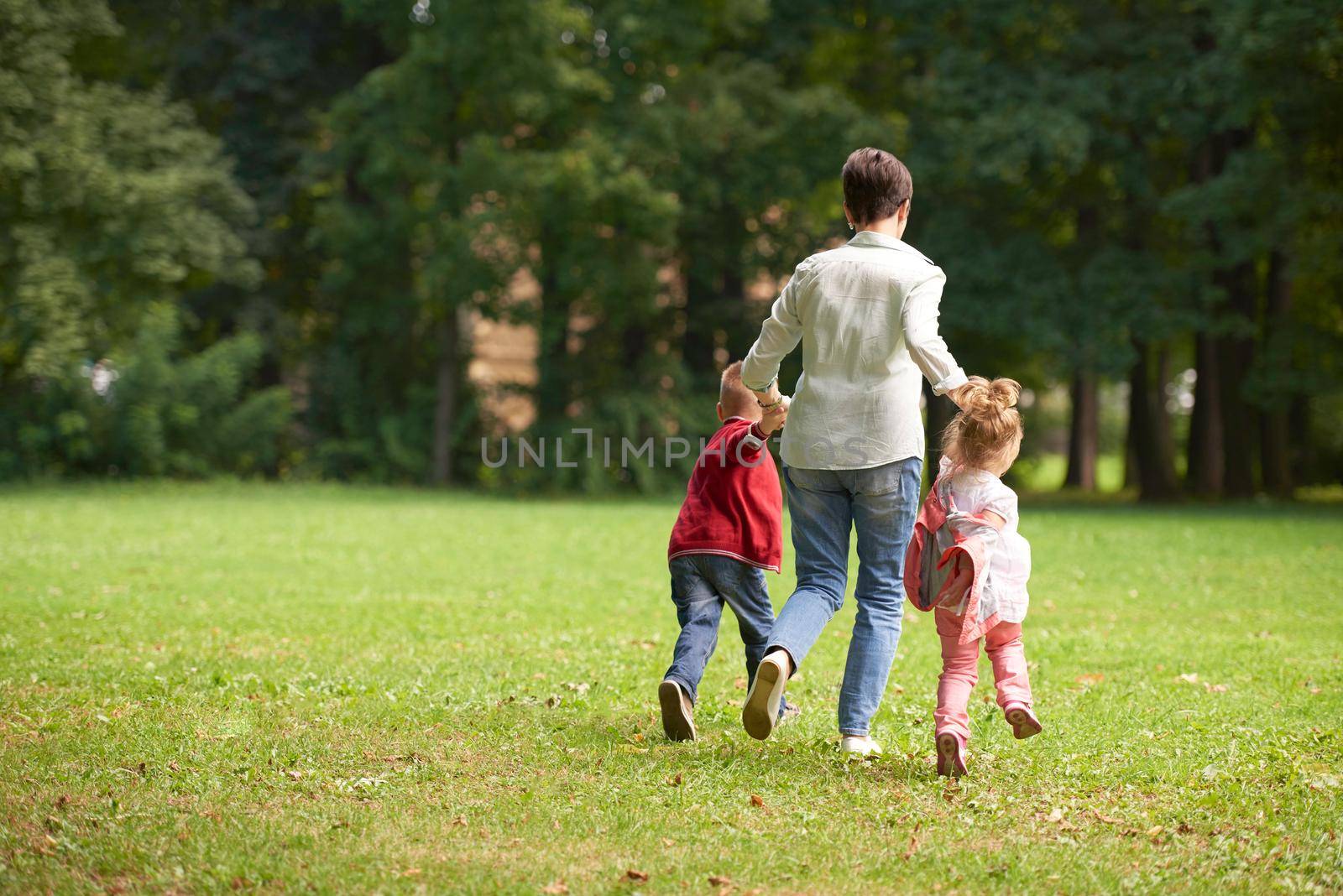 happy family playing together outdoor in park by dotshock