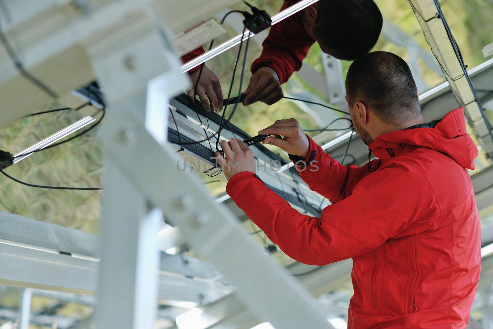 Male engineer at work place, solar panels plant industy in background