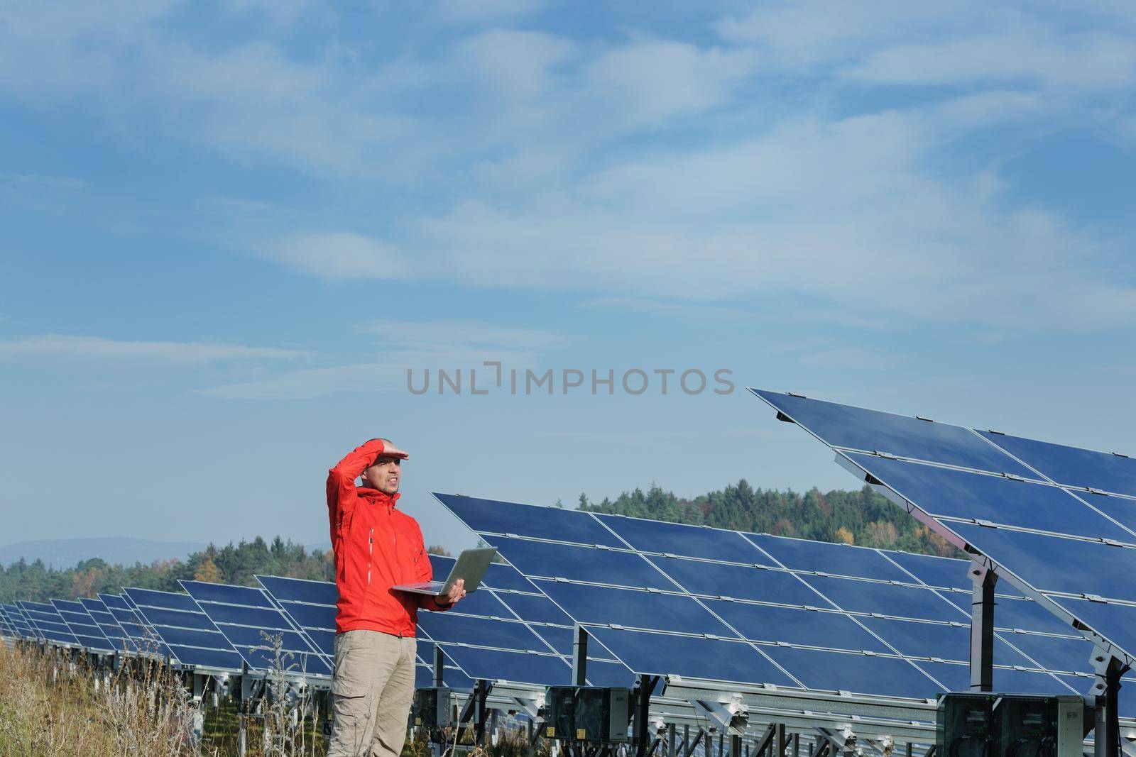 business man  engineer using laptop at solar panels plant eco energy field  in background