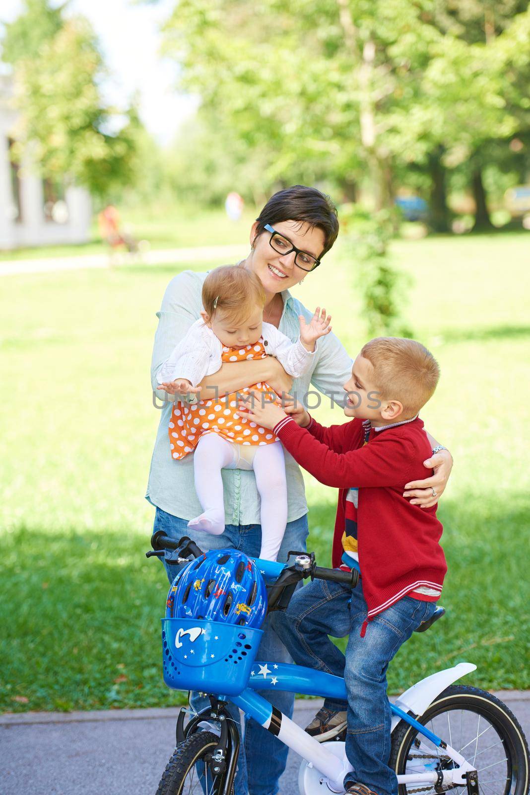 portrait of happy young family,  mother and  kids have fun in park