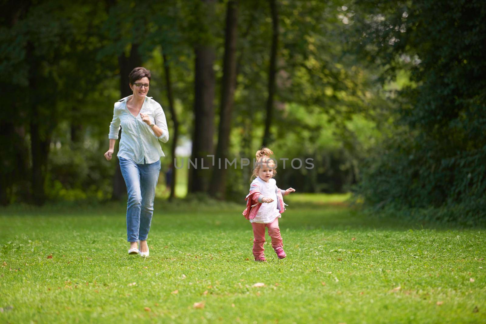 happy family playing together outdoor  in park mother with kids  running on grass