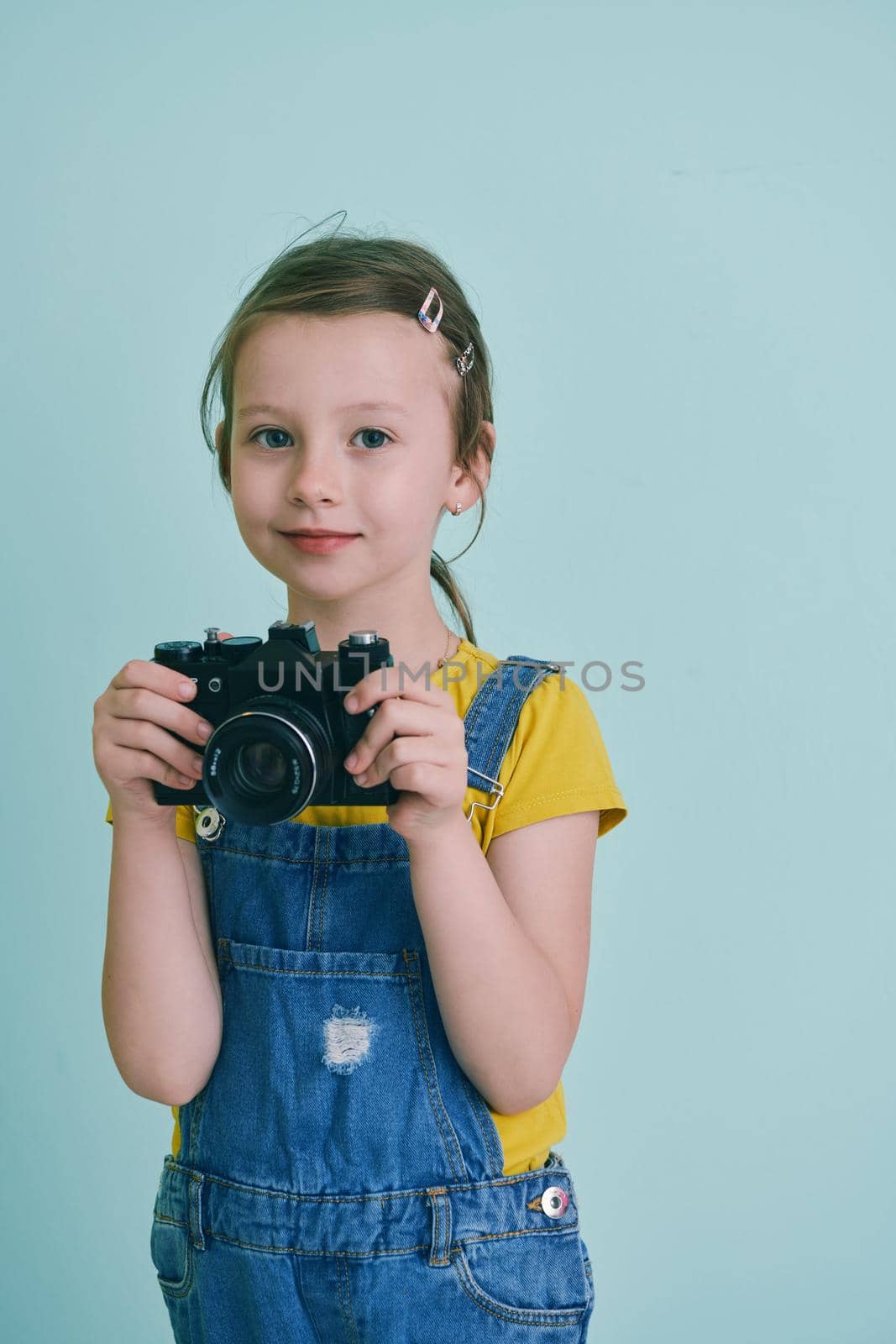 Cute little girl taking picture using  film photo camera by dotshock