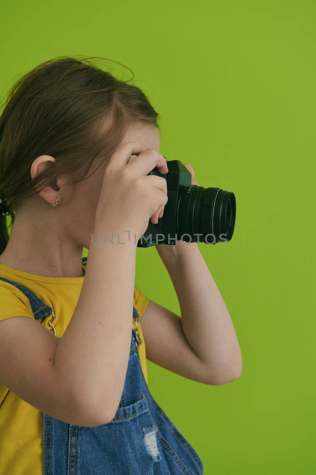 Cute little girl taking picture using  film photo camera by dotshock