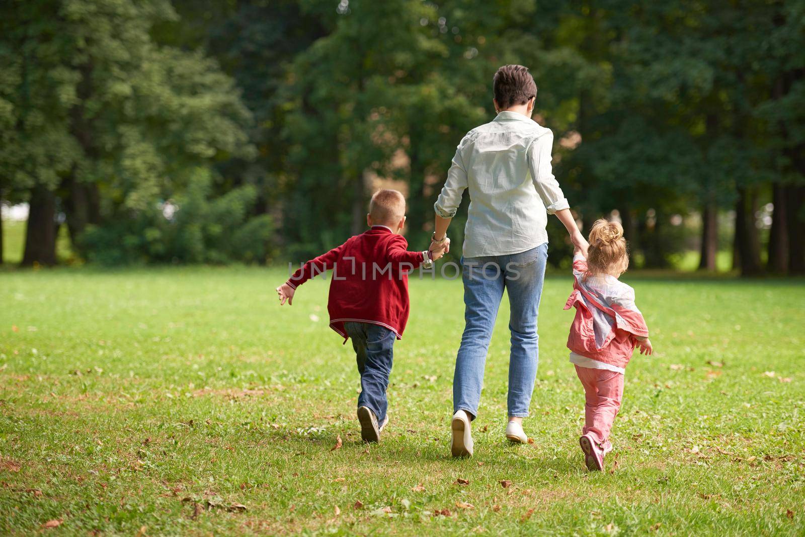 happy family playing together outdoor in park by dotshock