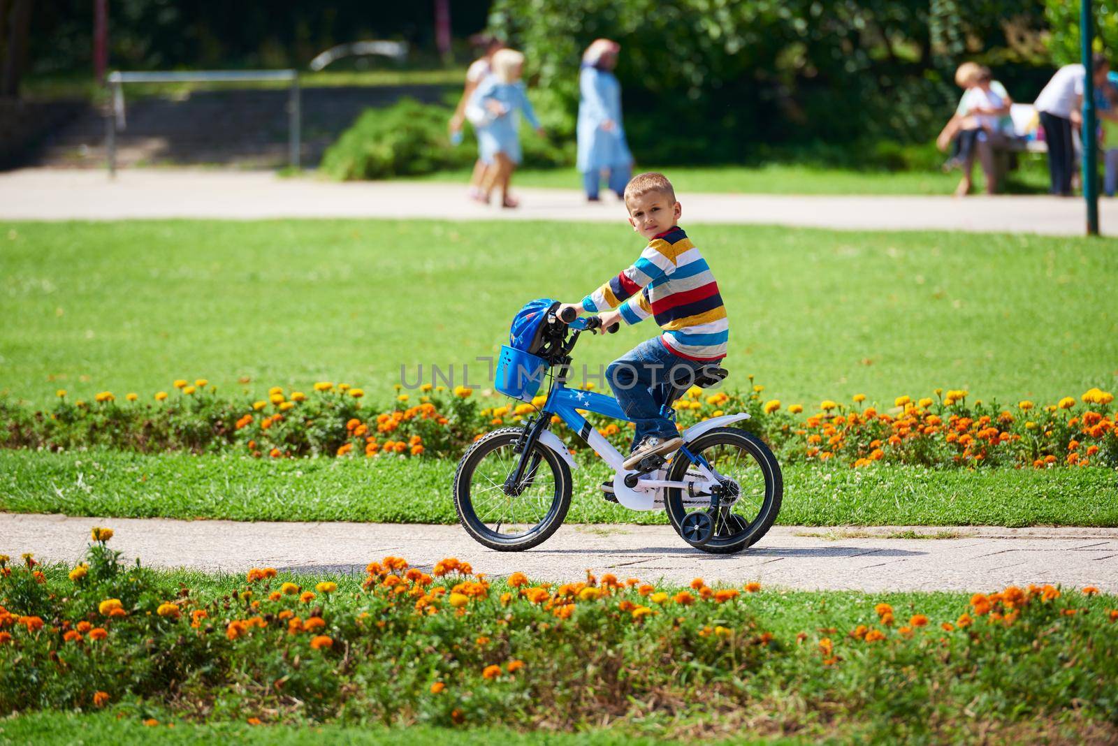 happy little boy have fun in park and learning to ride his first bike