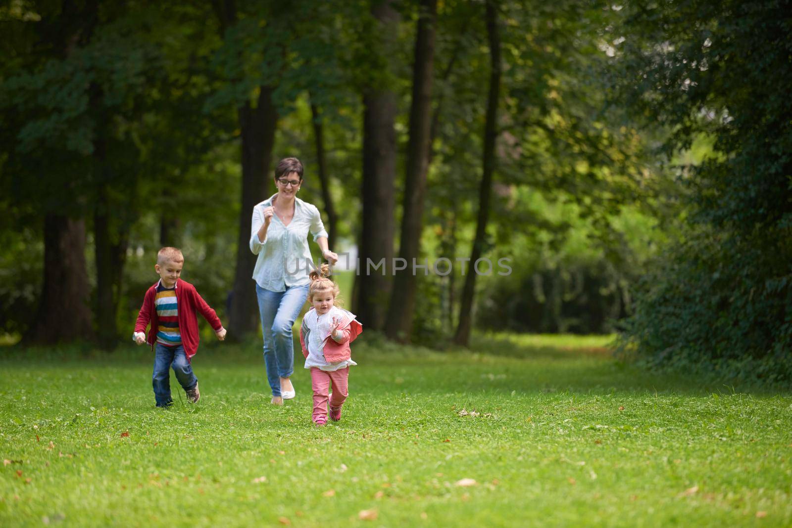 happy family playing together outdoor in park by dotshock