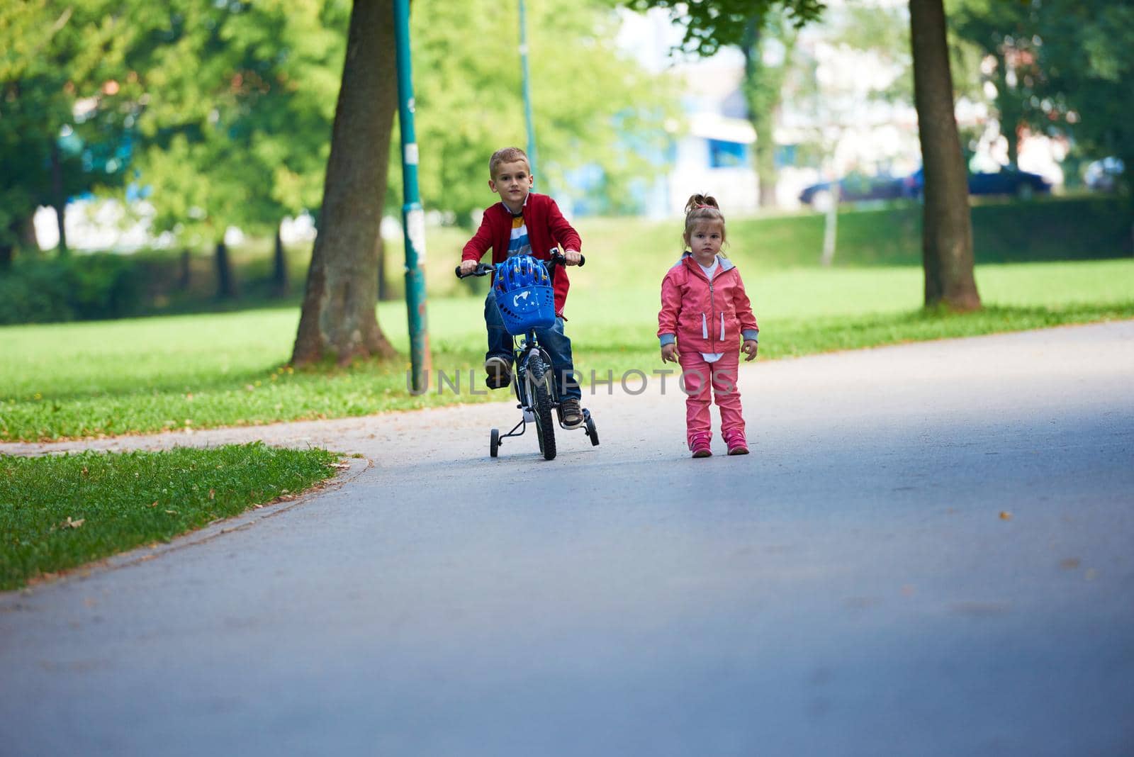 happy kids in park, boy and girl in nature with bicycle have fun