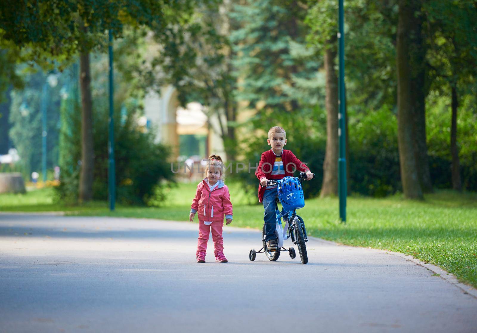 happy kids in park, boy and girl in nature with bicycle have fun