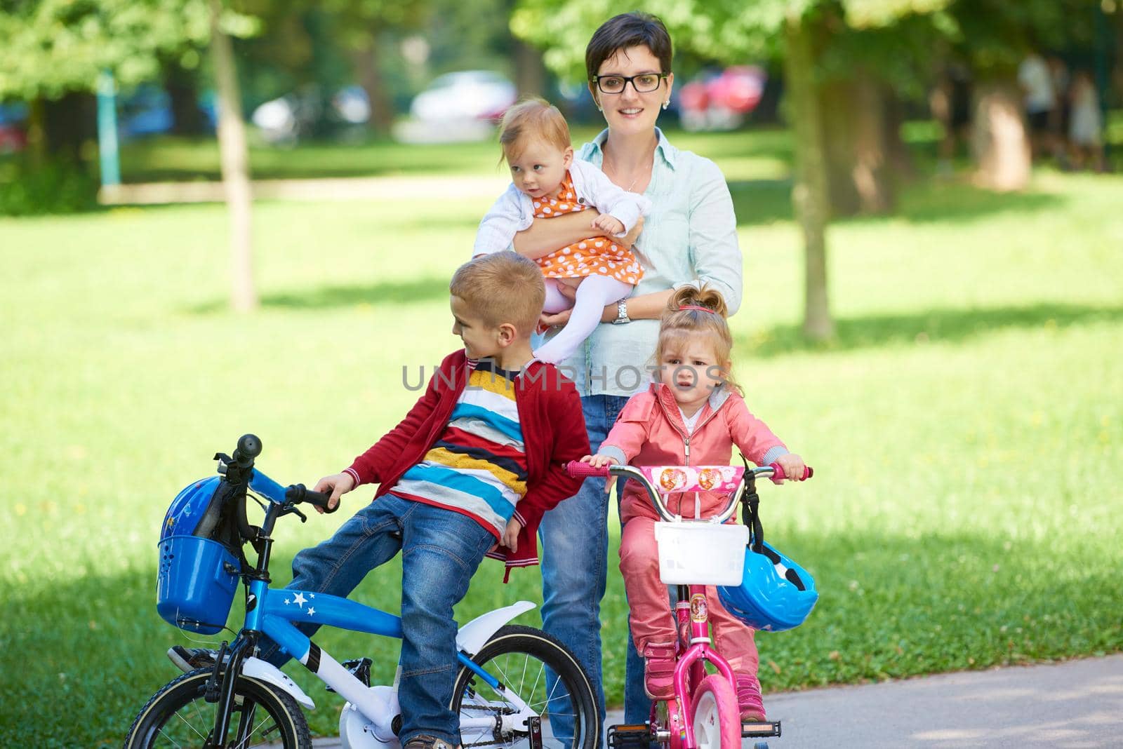 portrait of happy young family,  mother and  kids have fun in park