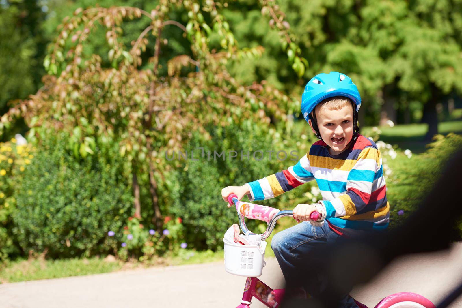 happy boy learning to ride his first bike by dotshock