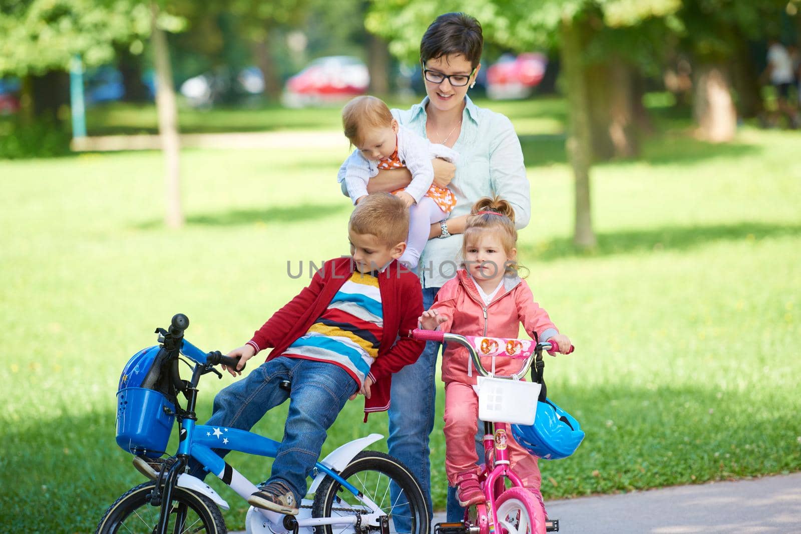 portrait of happy young family,  mother and  kids have fun in park