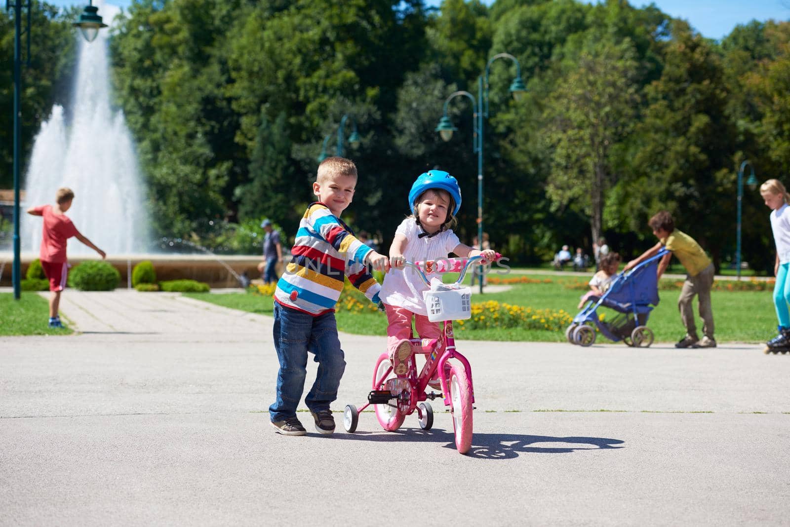 Boy and girl in park learning to ride a bike by dotshock