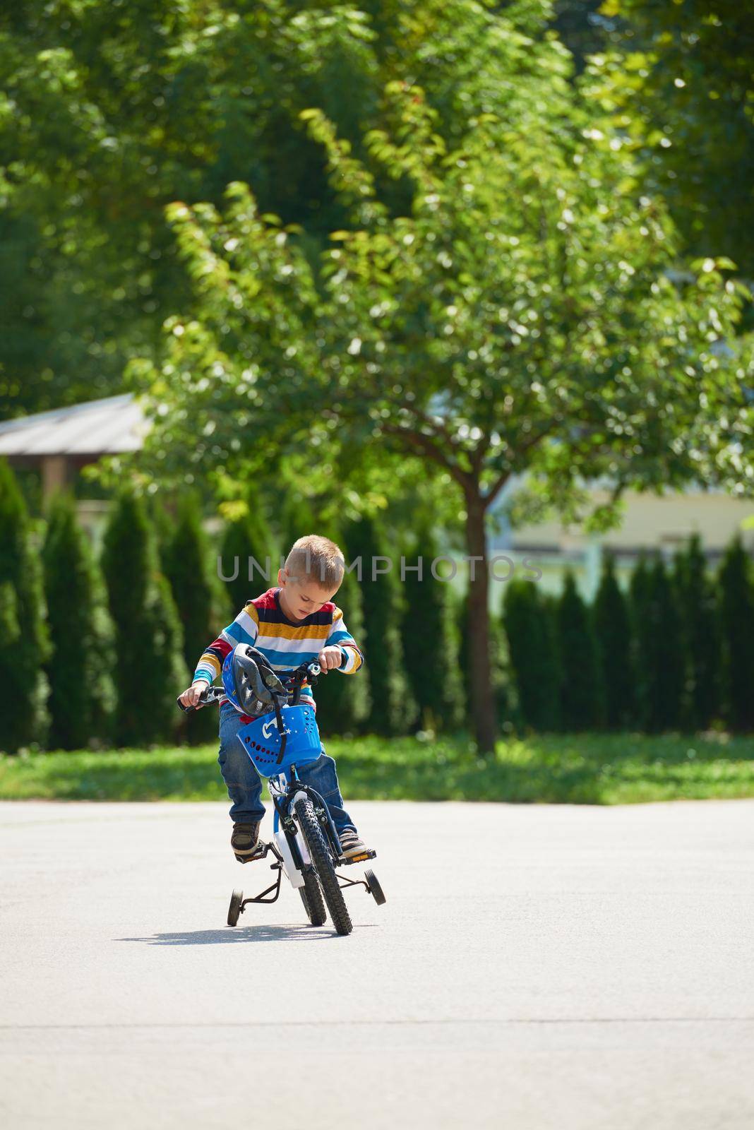 happy boy learning to ride his first bike by dotshock