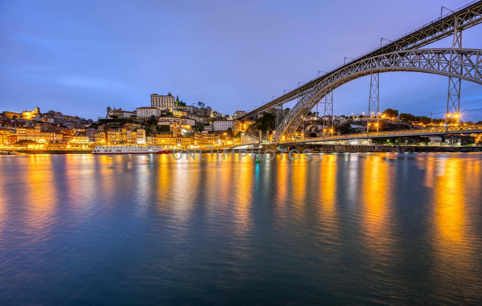 The old town of Porto with the river Douro and the famous iron bridge at dusk