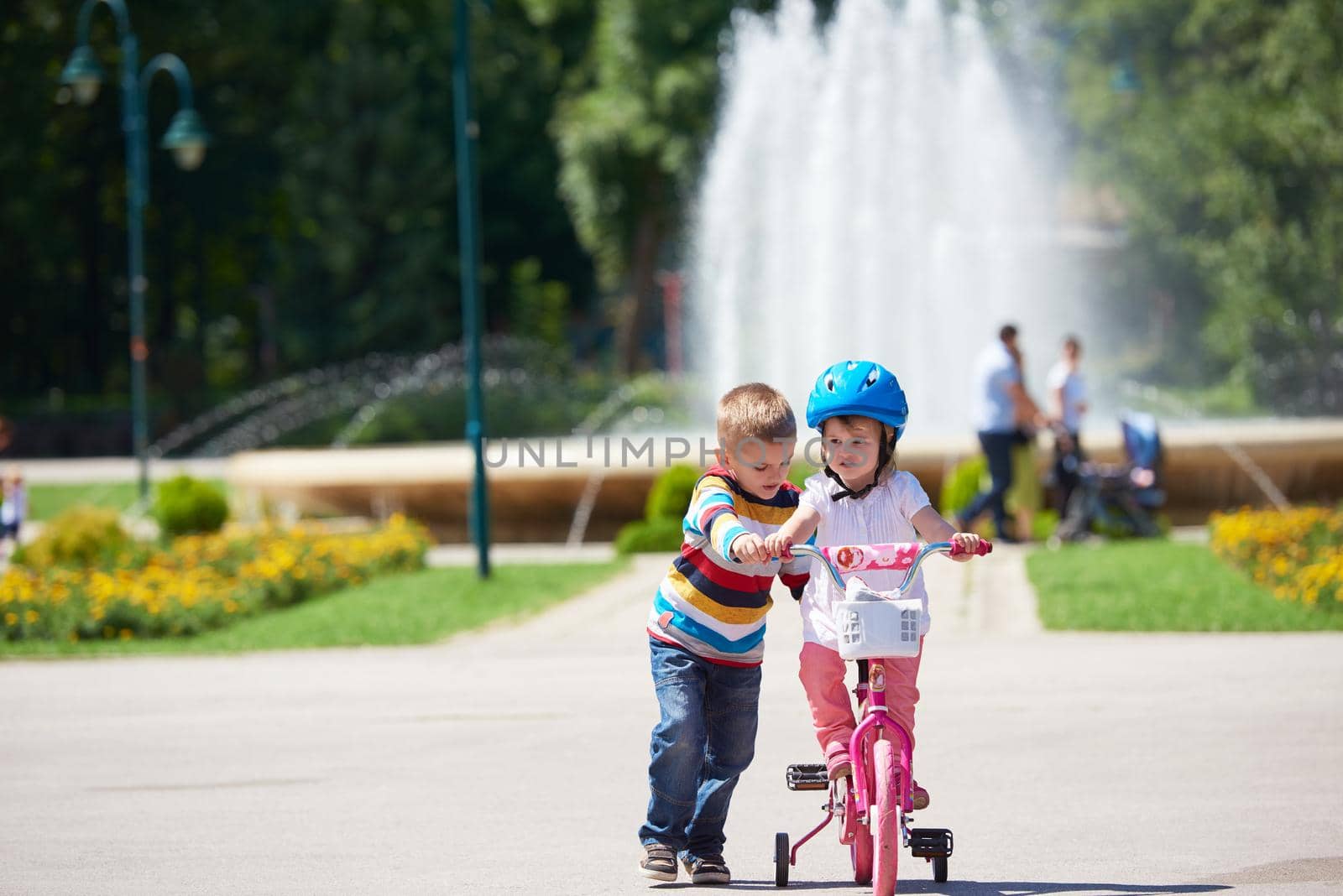 Happy childrens outdoor,  brother and sister in park have fun. Boy and girl in park learning to ride a bike.