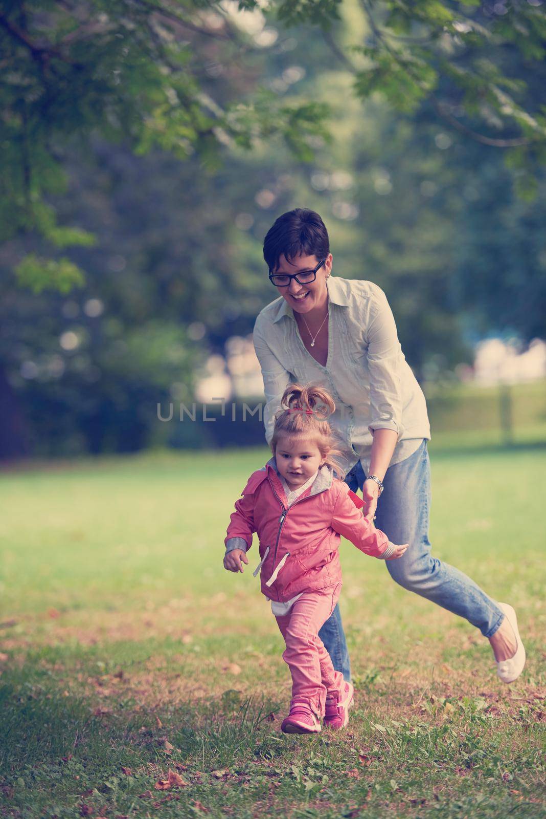 happy family playing together outdoor  in park mother with kids  running on grass