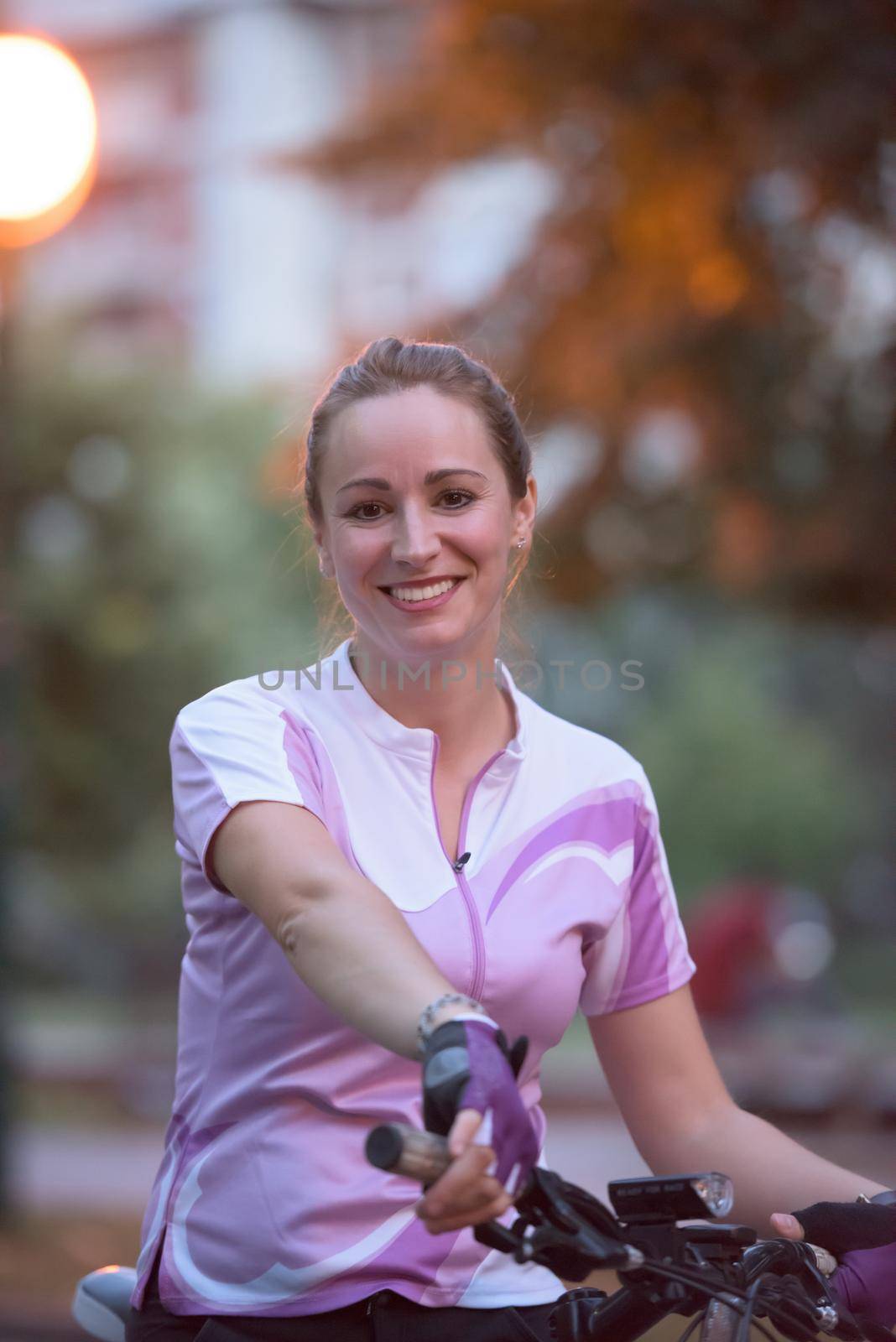 portrait of sporty happy woman with bike in park,  taking brake and relaxing after exercise