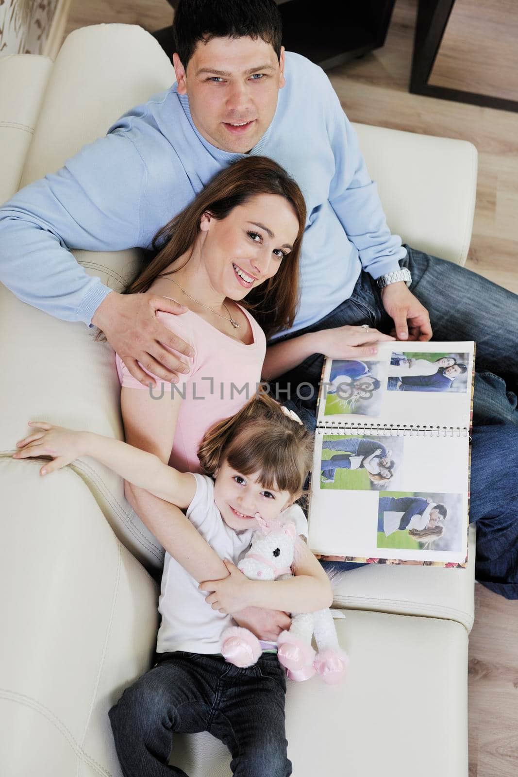 happy family looking photos at home by dotshock