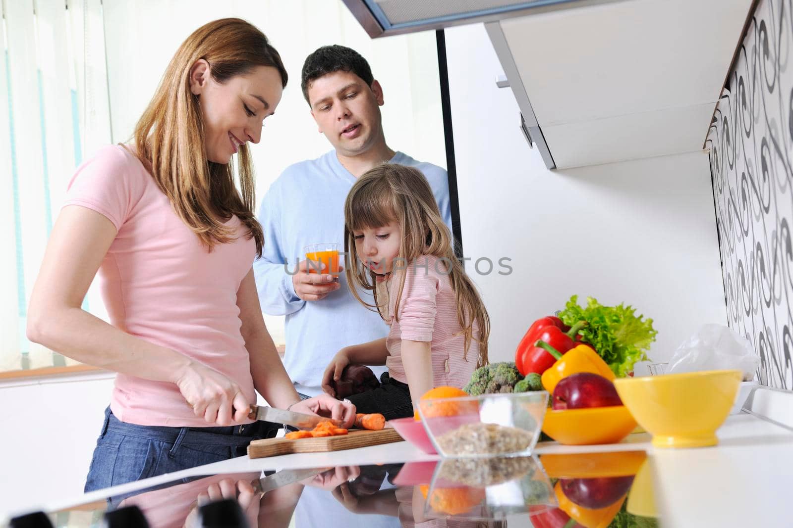 happy young family have lunch time with fresh fruits and vegetable food in bright kitchen 