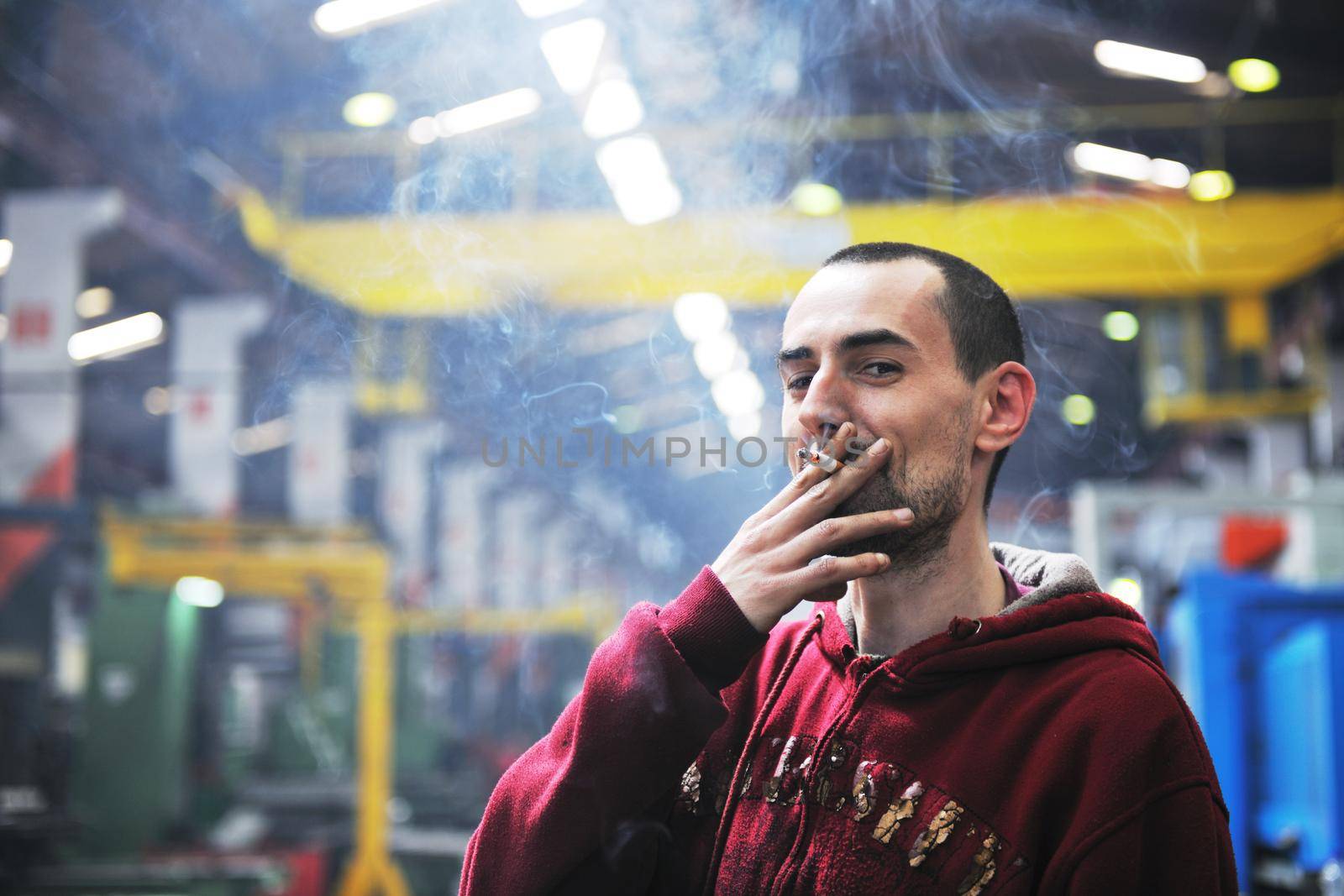 industry worker smoke cigarette at job in company at big bright hall