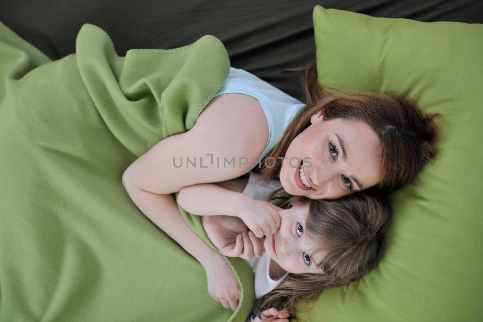 happy young family at home relaxing in bed 