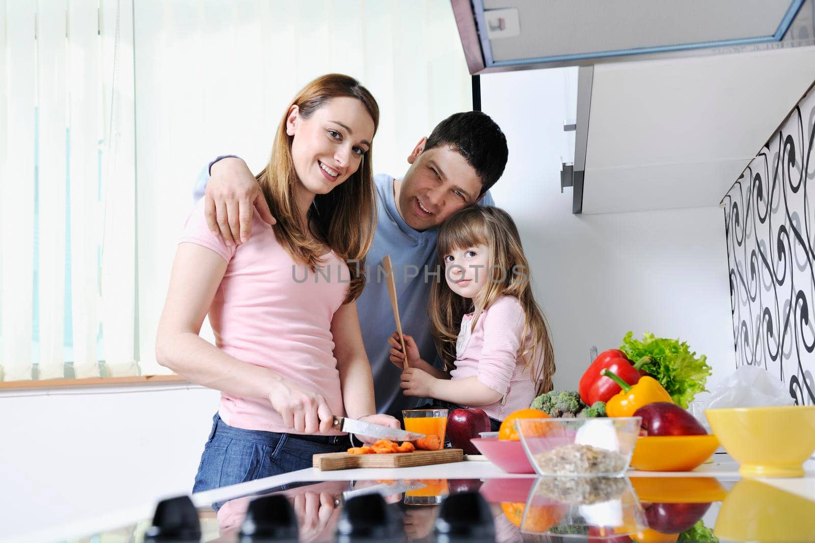 happy young family have lunch time with fresh fruits and vegetable food in bright kitchen 