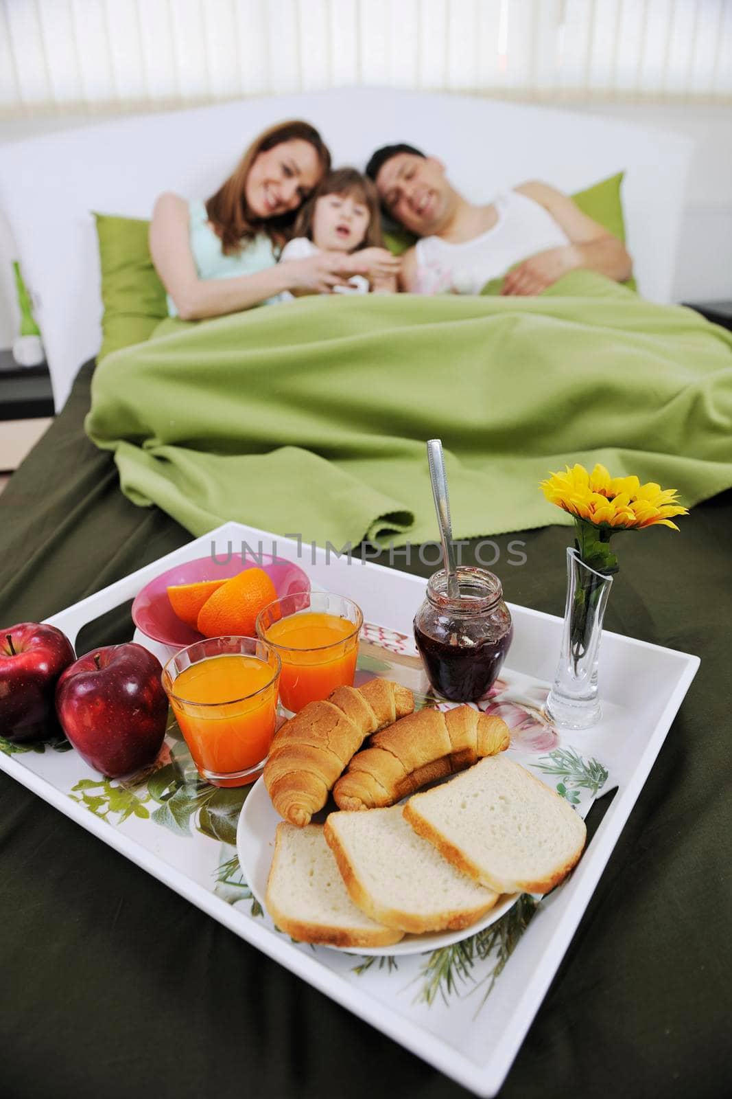 happy young family eat breakfast in bed at morning 