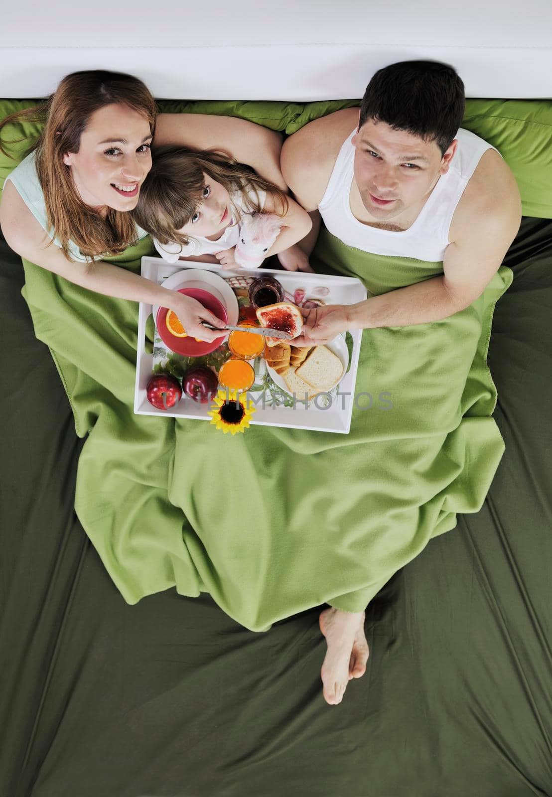 happy young family eat breakfast in bed at morning 