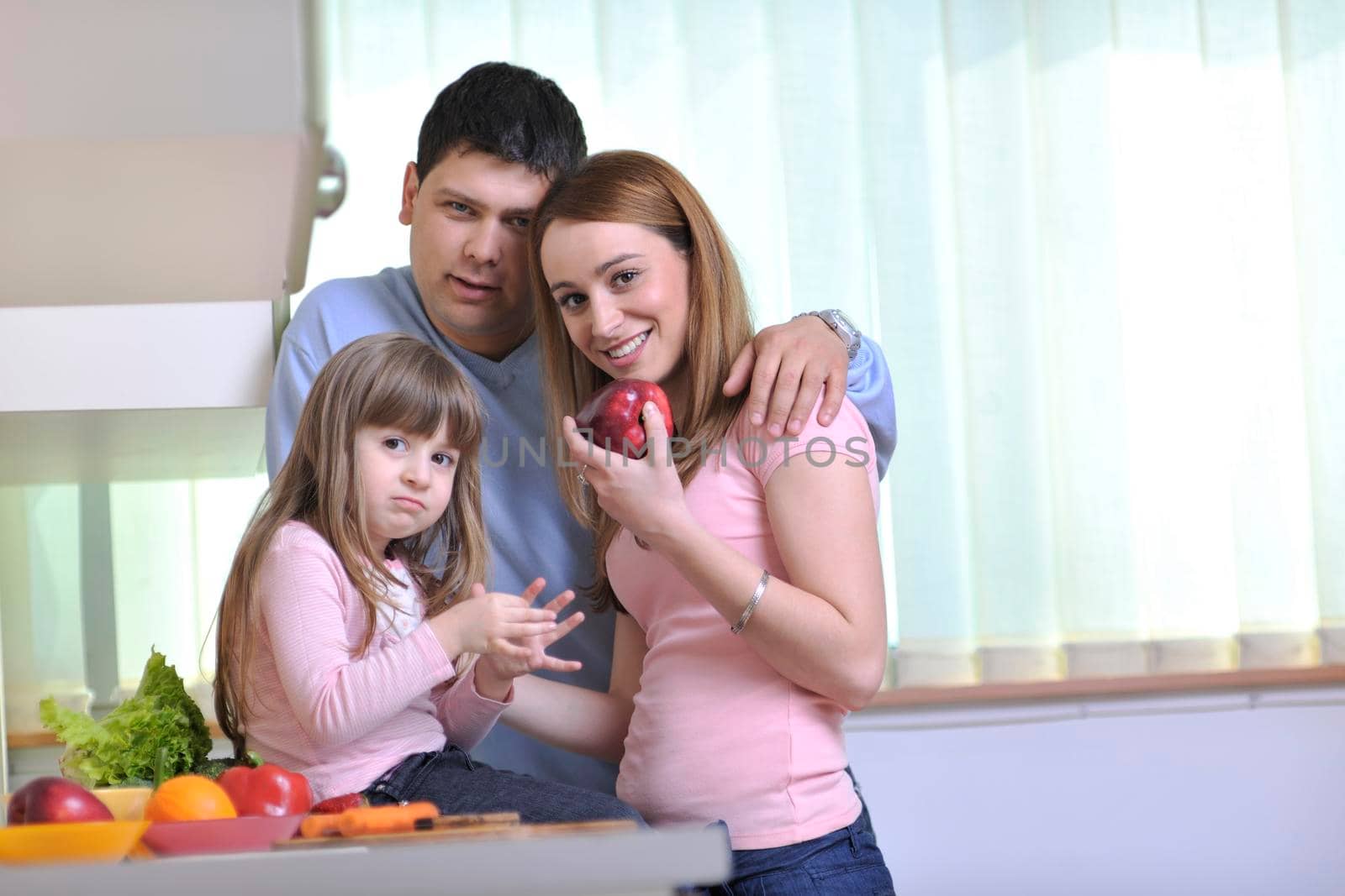 happy young family have lunch time with fresh fruits and vegetable food in bright kitchen