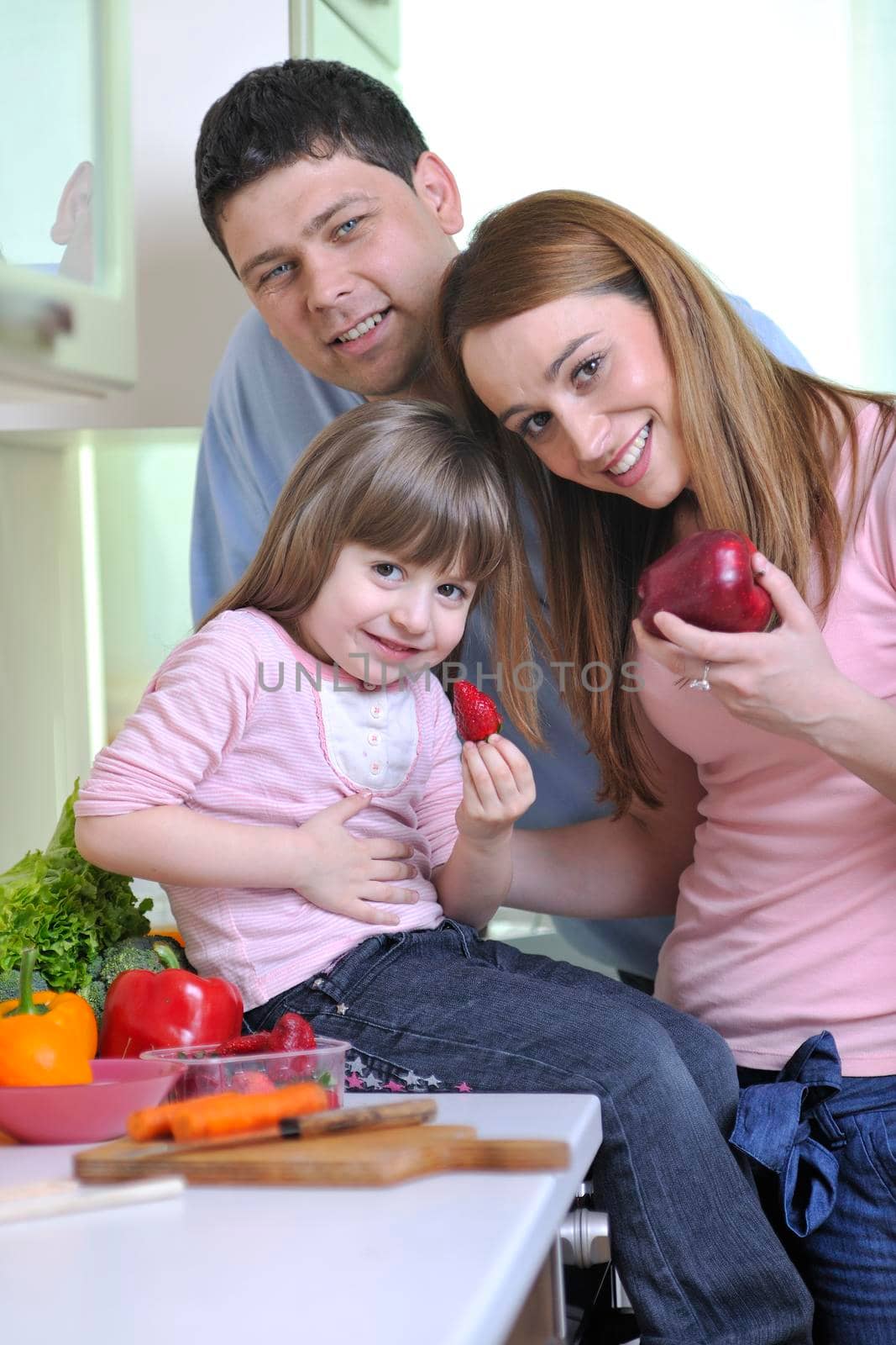 happy young family have lunch time with fresh fruits and vegetable food in bright kitchen 