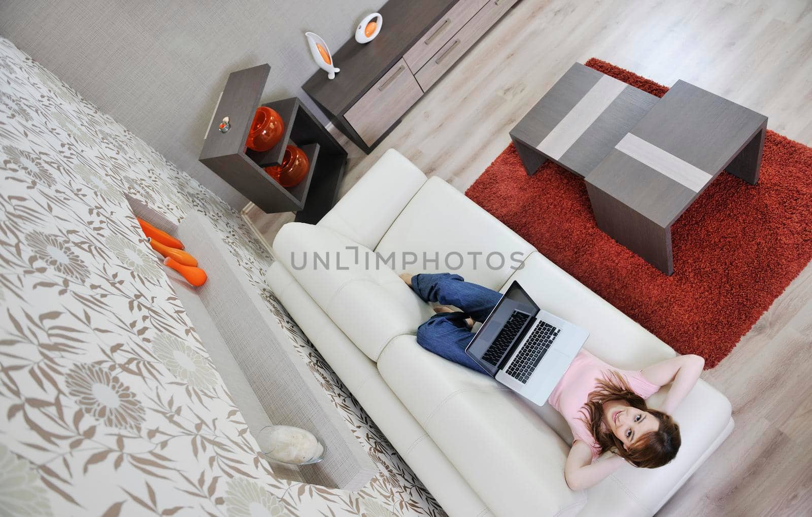 beautiful young woman relaxing at moder home while working wireless on laptop computer