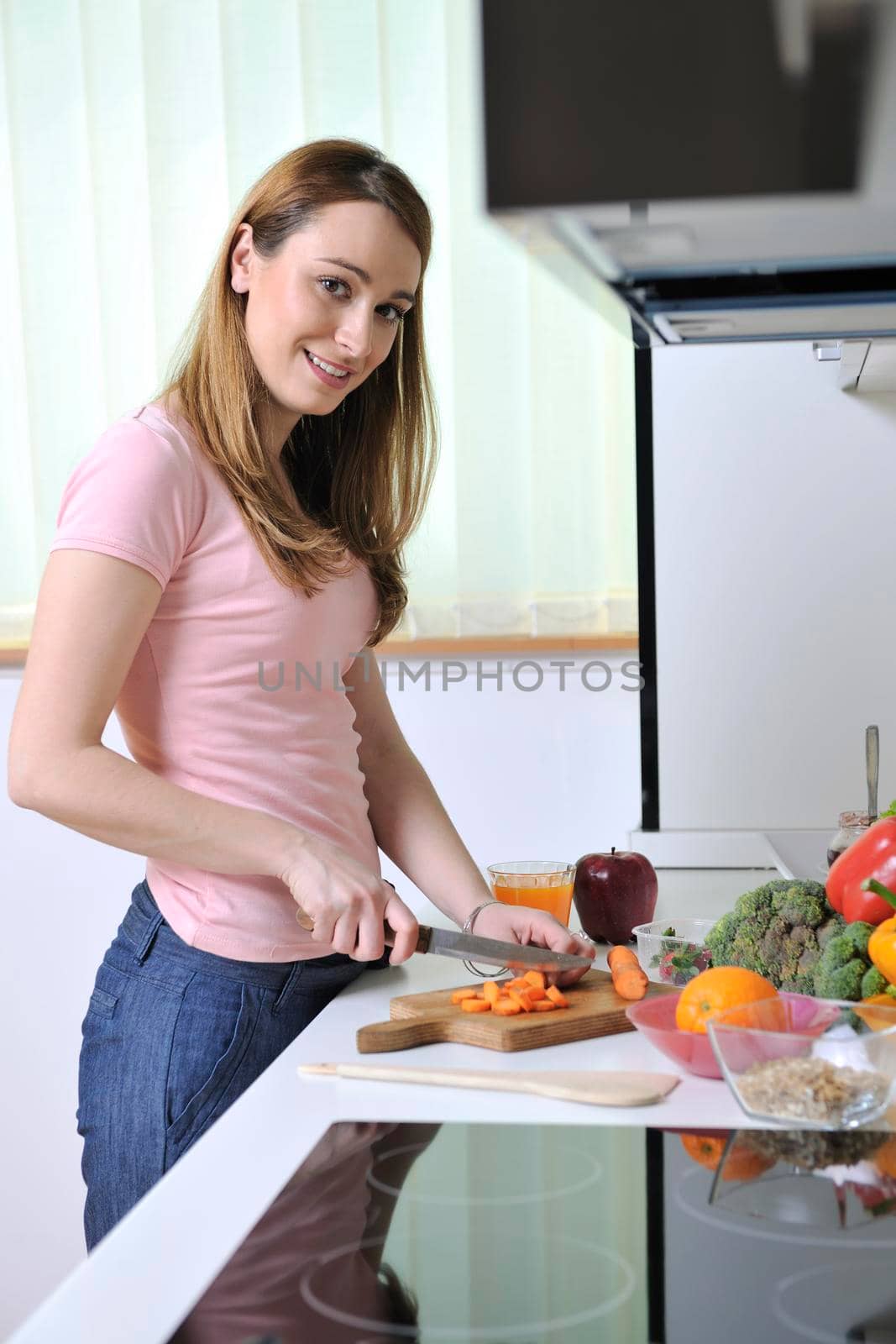 one happy young  woman with apple in kitchen and other food and vegetables