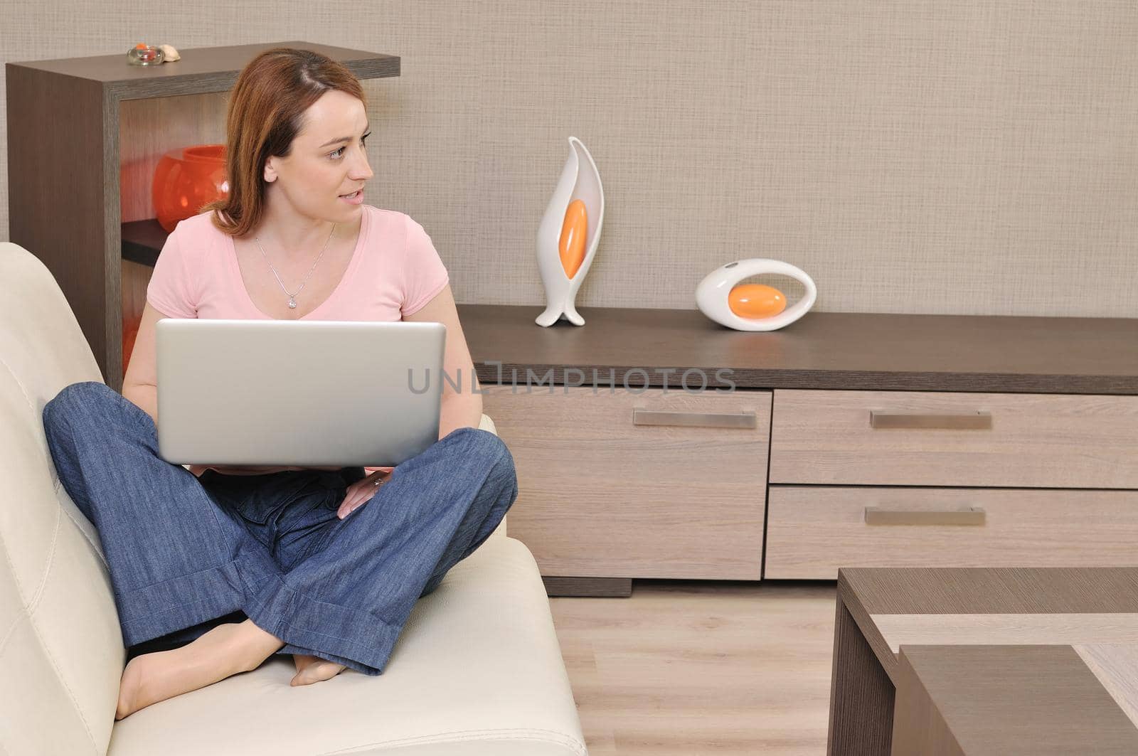 beautiful young woman relaxing at moder home while working wireless on laptop computer