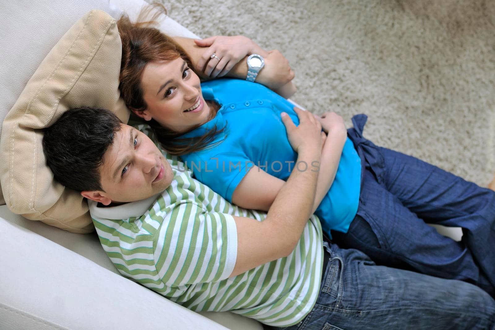 couple relax at home on sofa in living room by dotshock