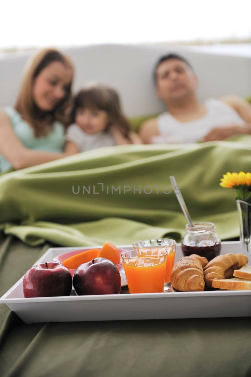 happy young family eat breakfast in bed by dotshock