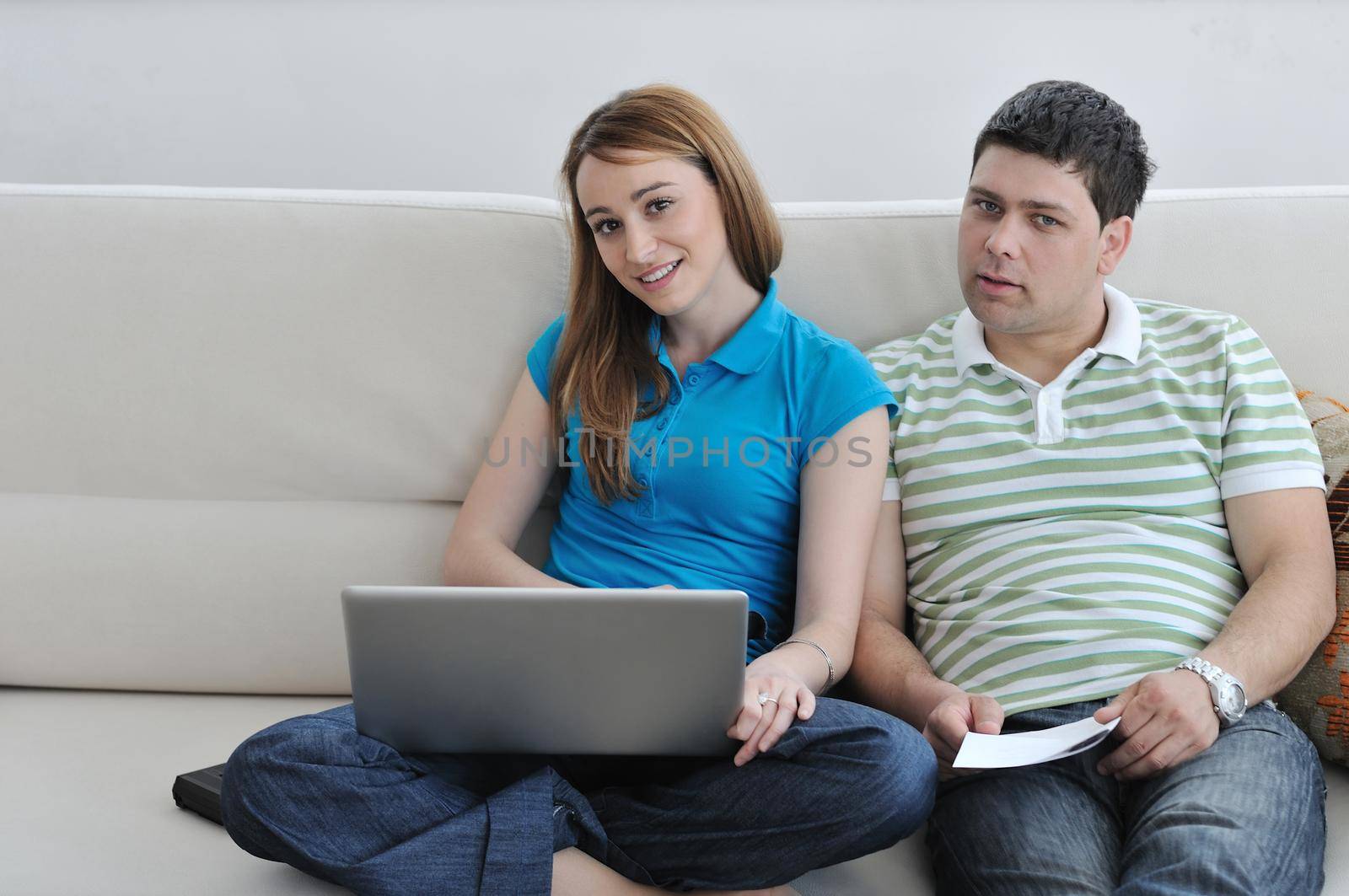 young couple working on laptop at home by dotshock