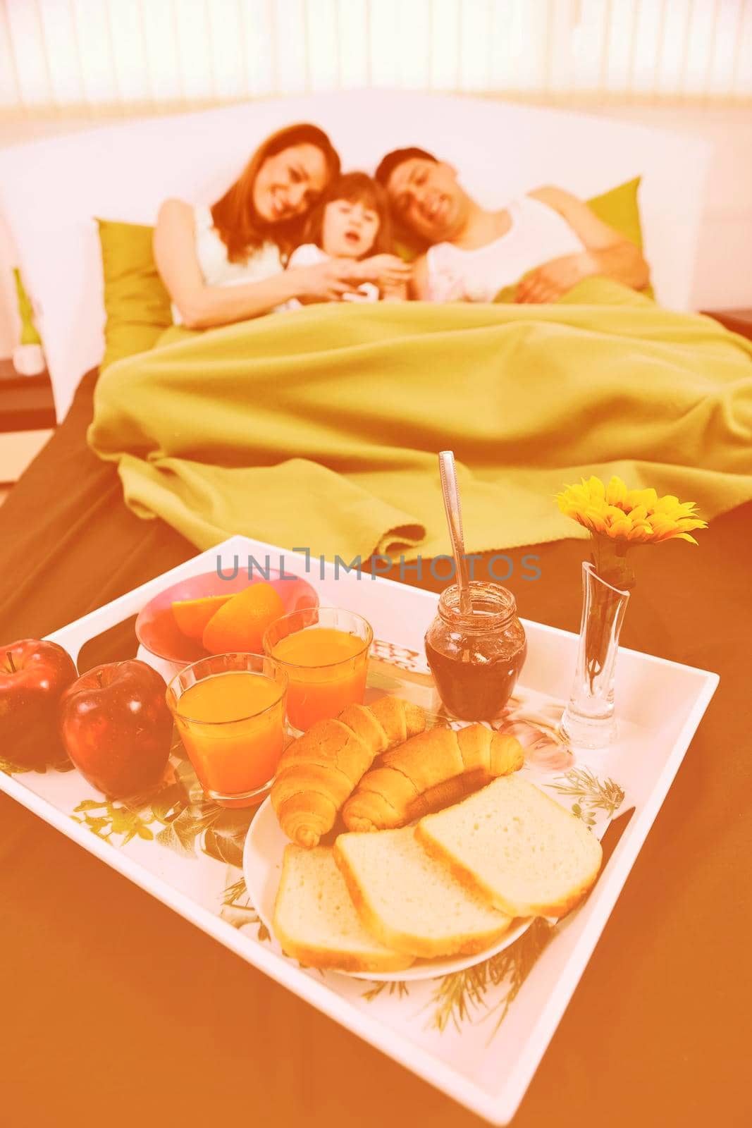 happy young family eat breakfast in bed at morning 