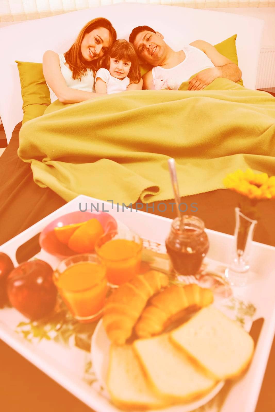 happy young family eat breakfast in bed at morning 