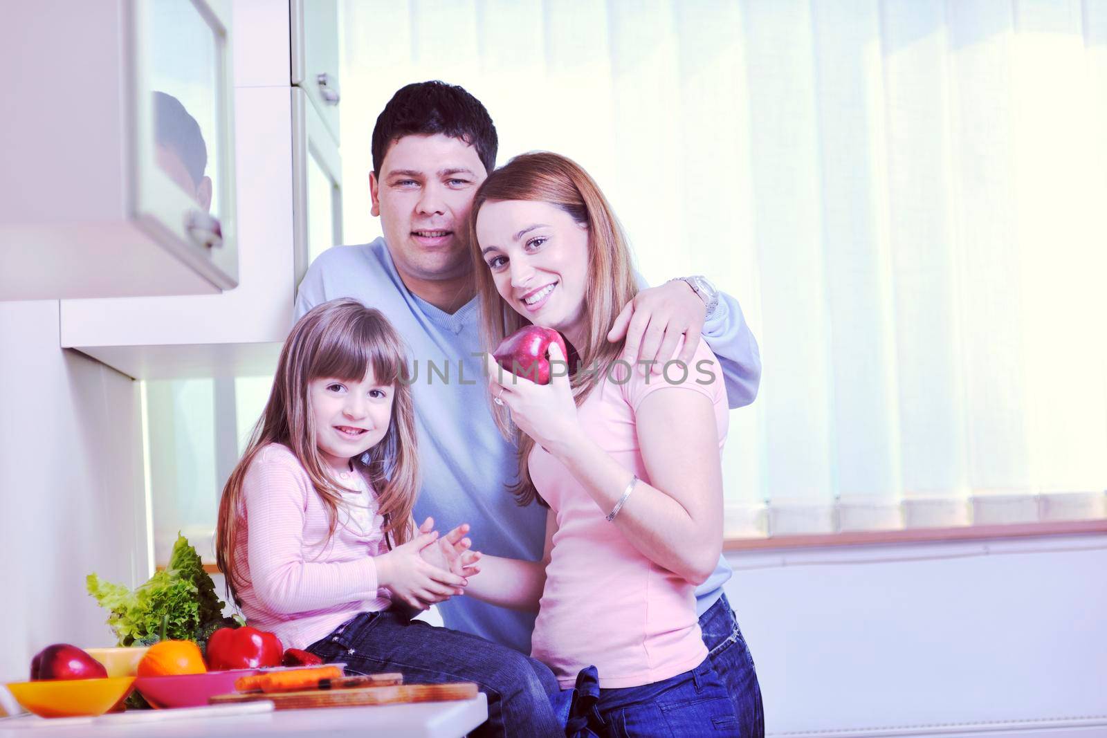 happy young family in kitchen by dotshock