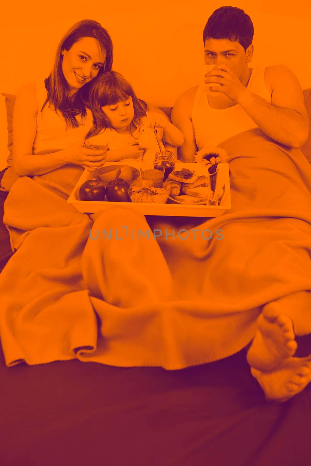 happy young family eat breakfast in bed at morning duo tone