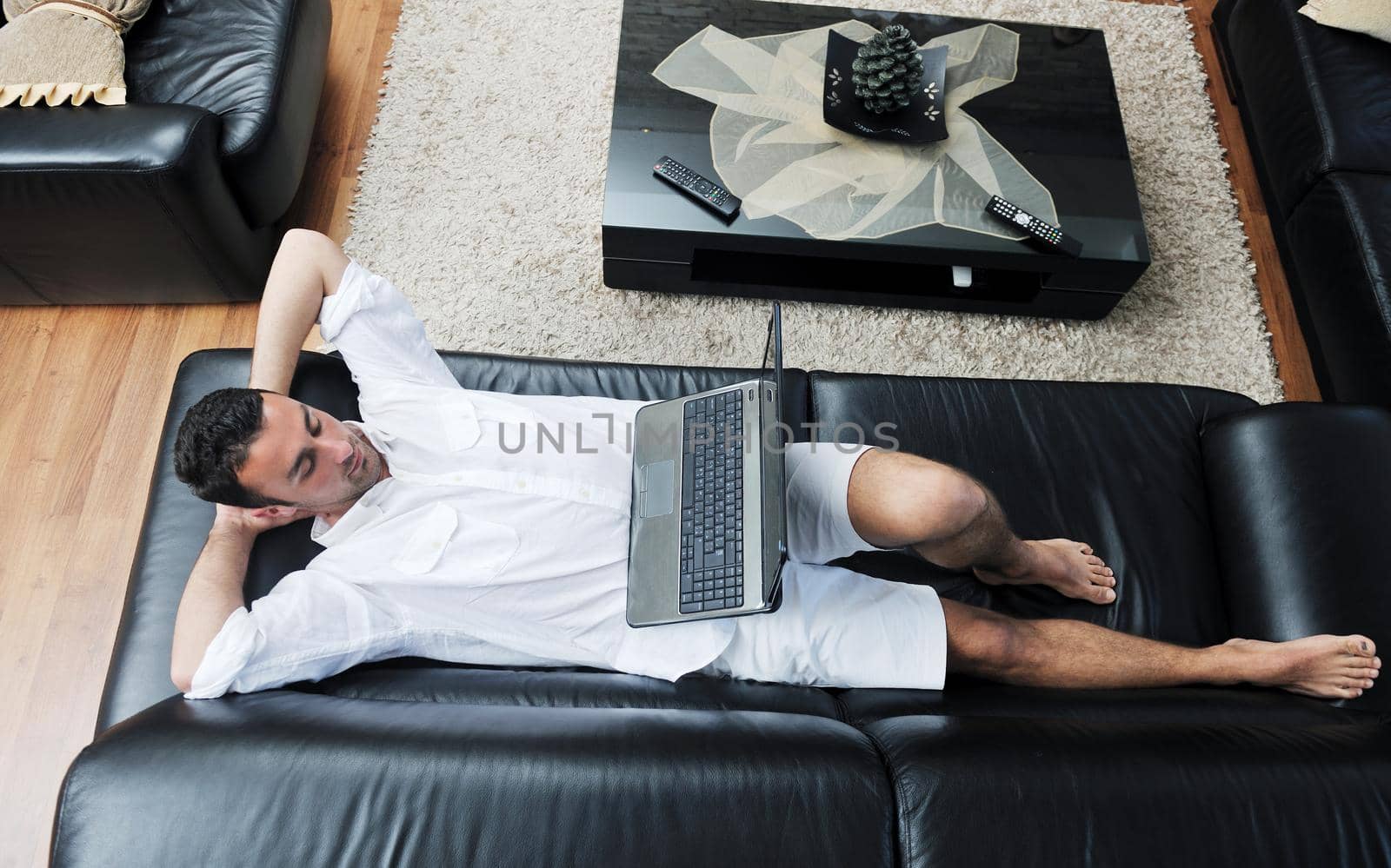 Portrait of a relaxed young guy using laptop at home indoor