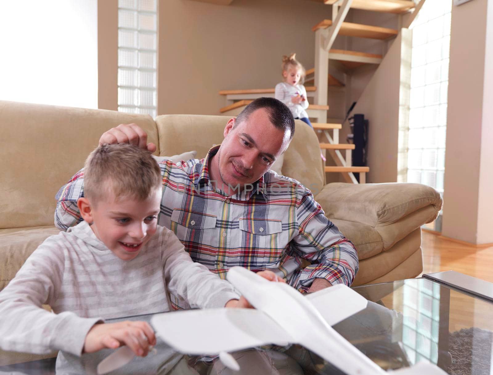 father and son assembling airplane toy at modern home living room indoor