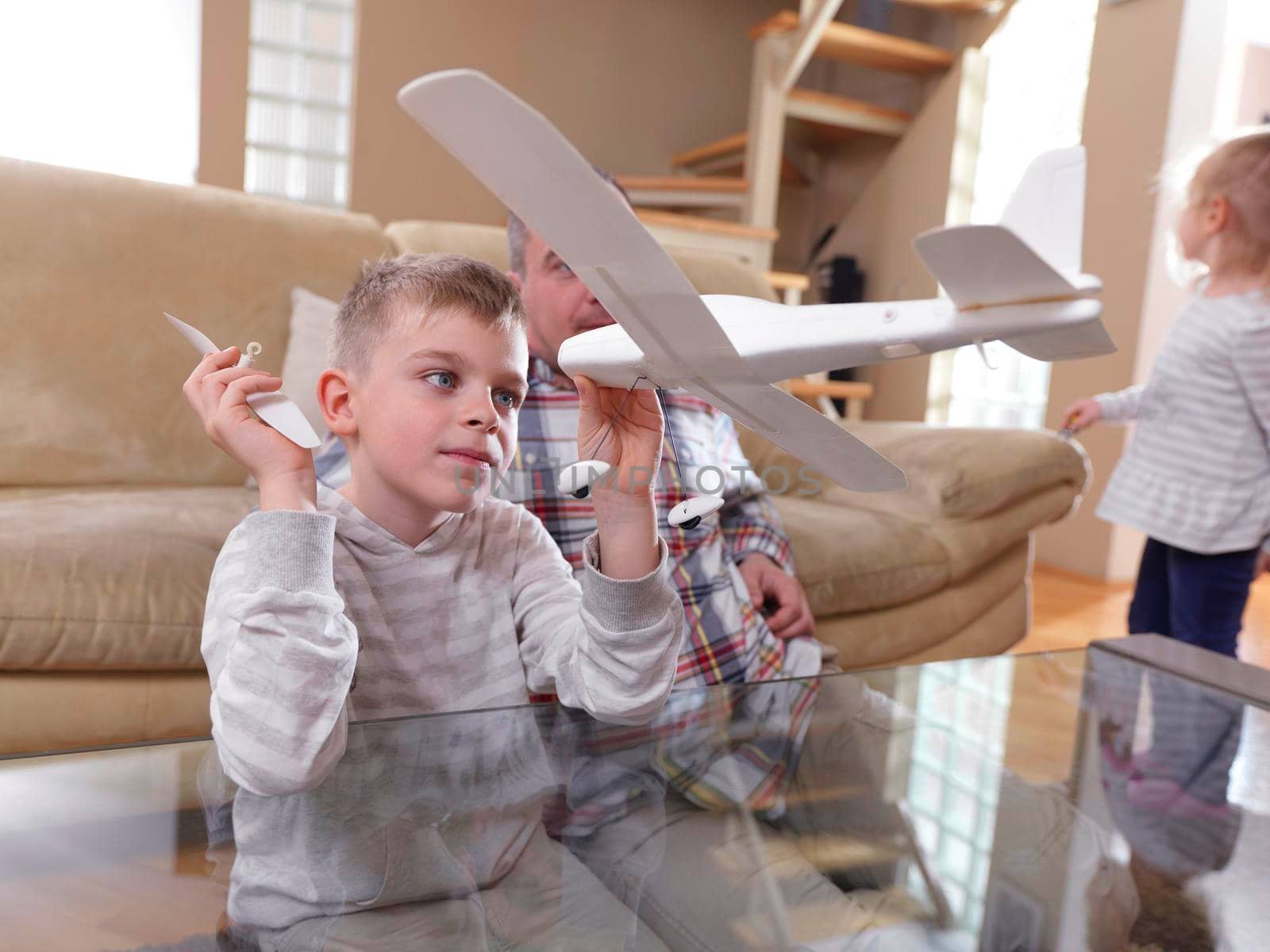 father and son assembling airplane toy at modern home living room indoor