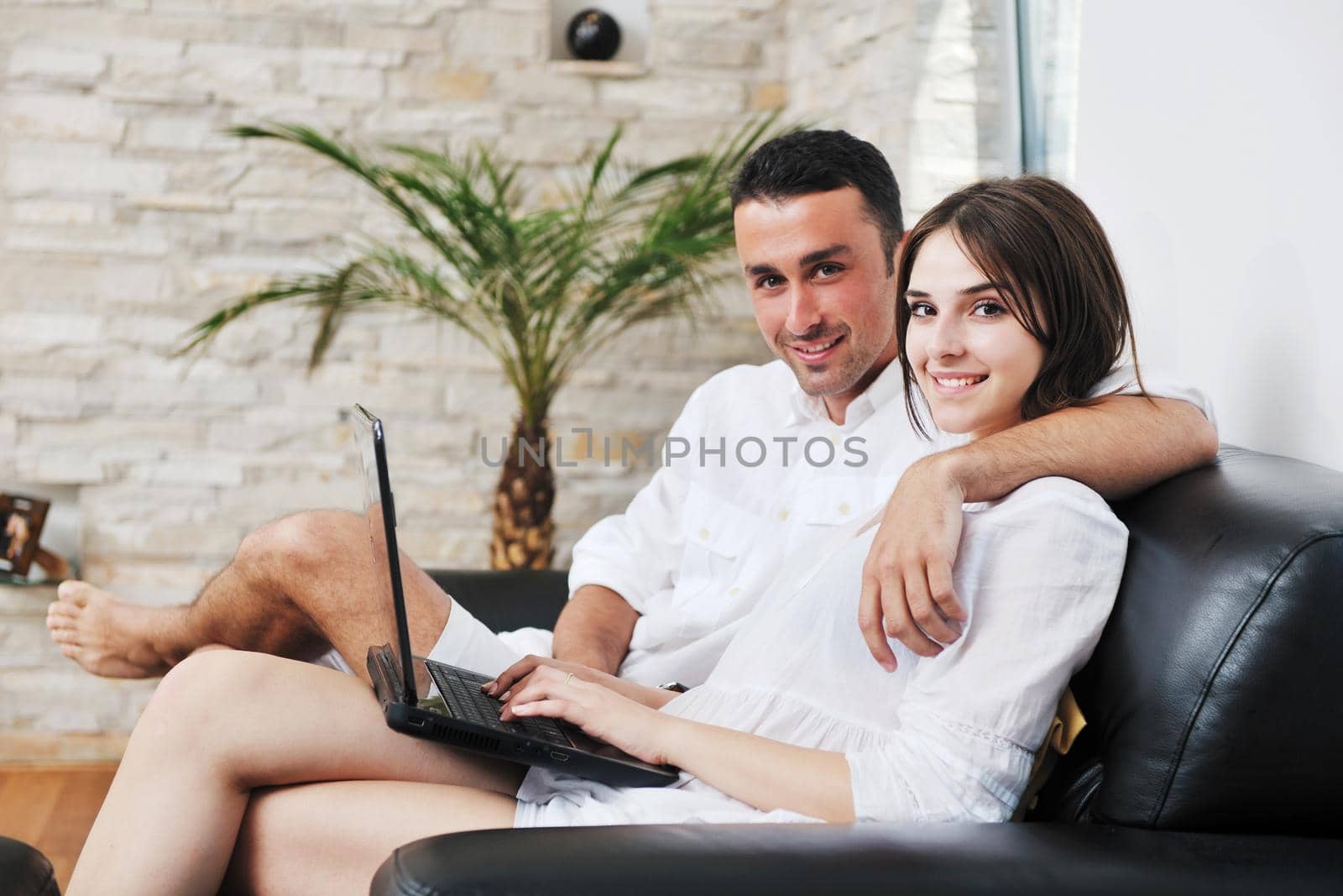 joyful couple relax and work on laptop computer at modern livingroom indoor home