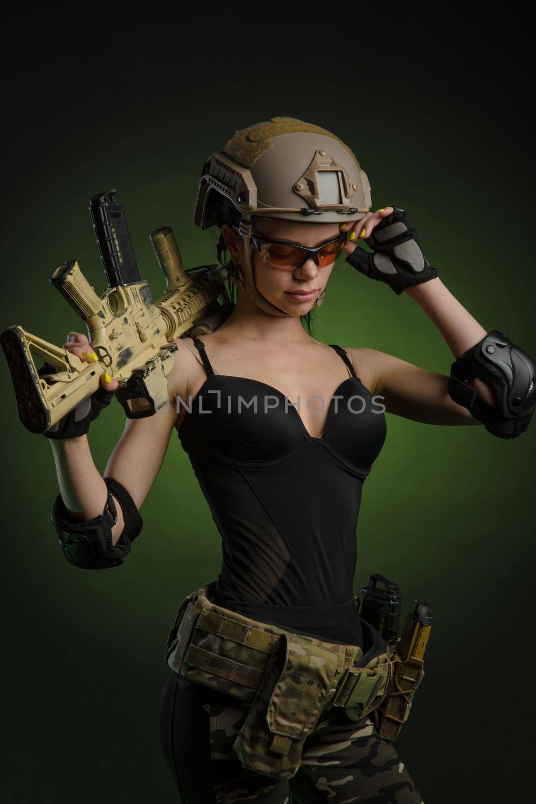 a soldier girl poses with an automatic rifle by Rotozey