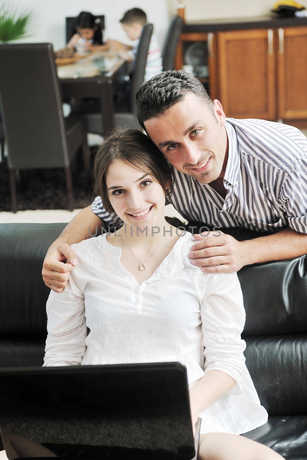 happy young family have fun and working on laptop at modern  home livingroom indoor