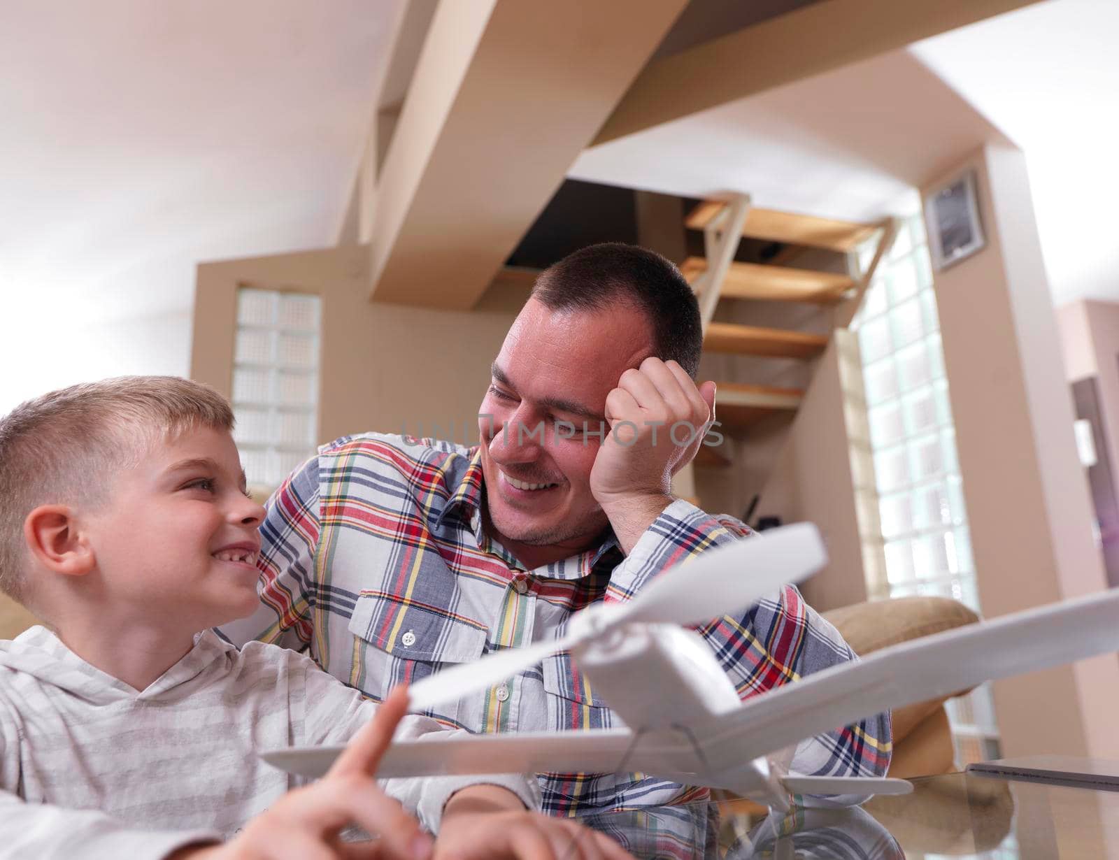 father and son assembling airplane toy at modern home living room indoor