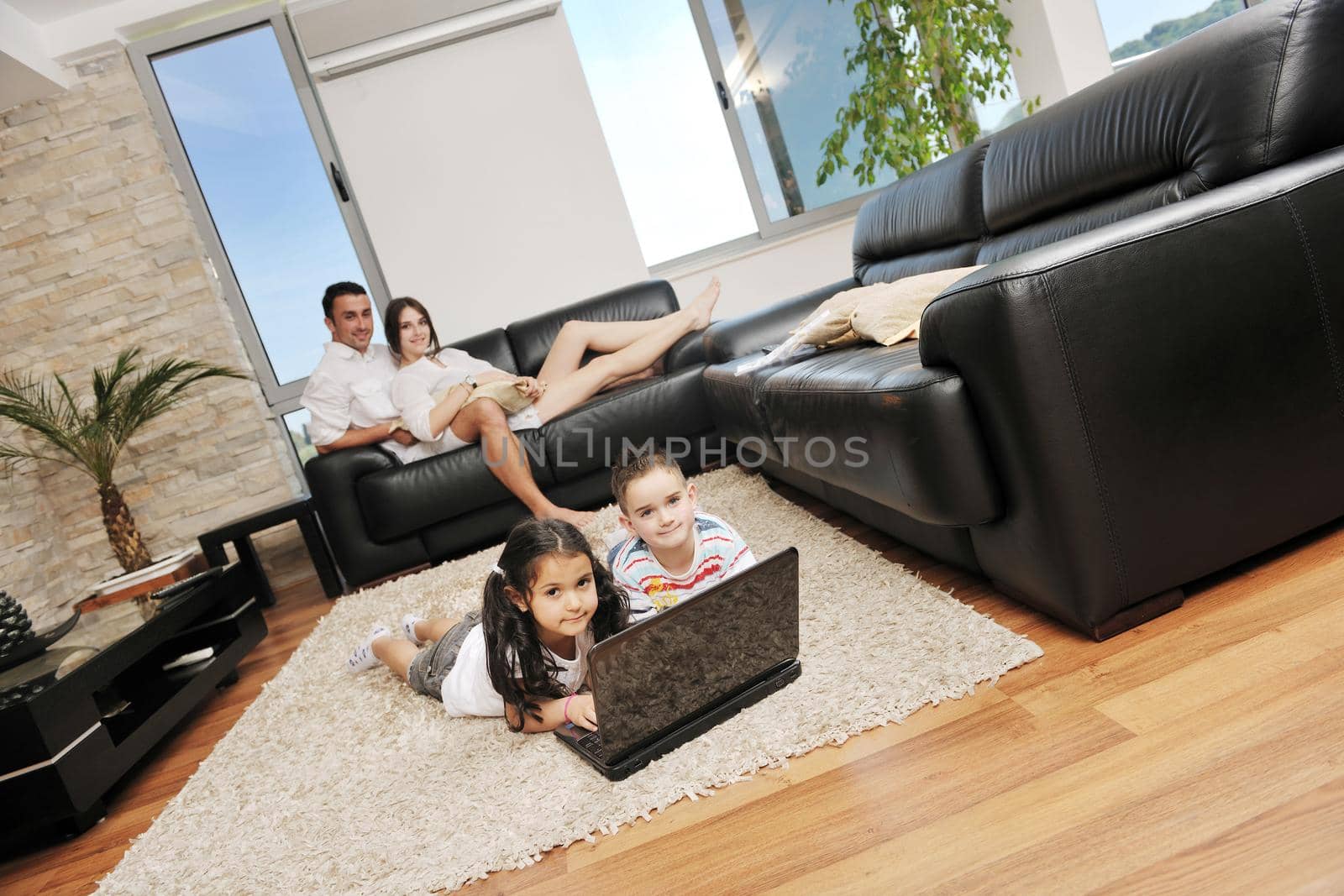 happy young family have fun and working on laptop at modern  home livingroom indoor